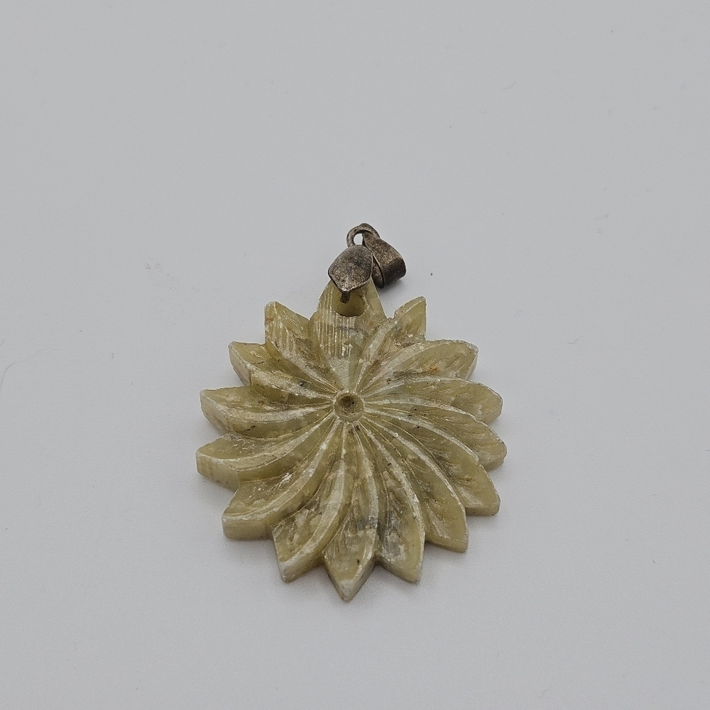 tan and greenish carved stone pendant